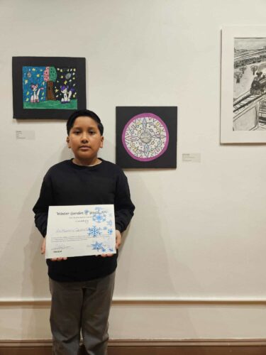 Anthony hold his certificate at the Winter Art Garden.