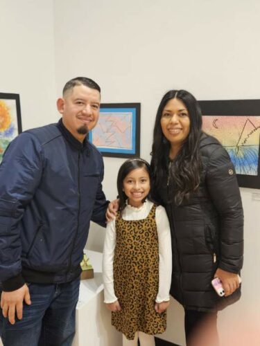 Miranda smiles with her family at the Winter Art Garden.